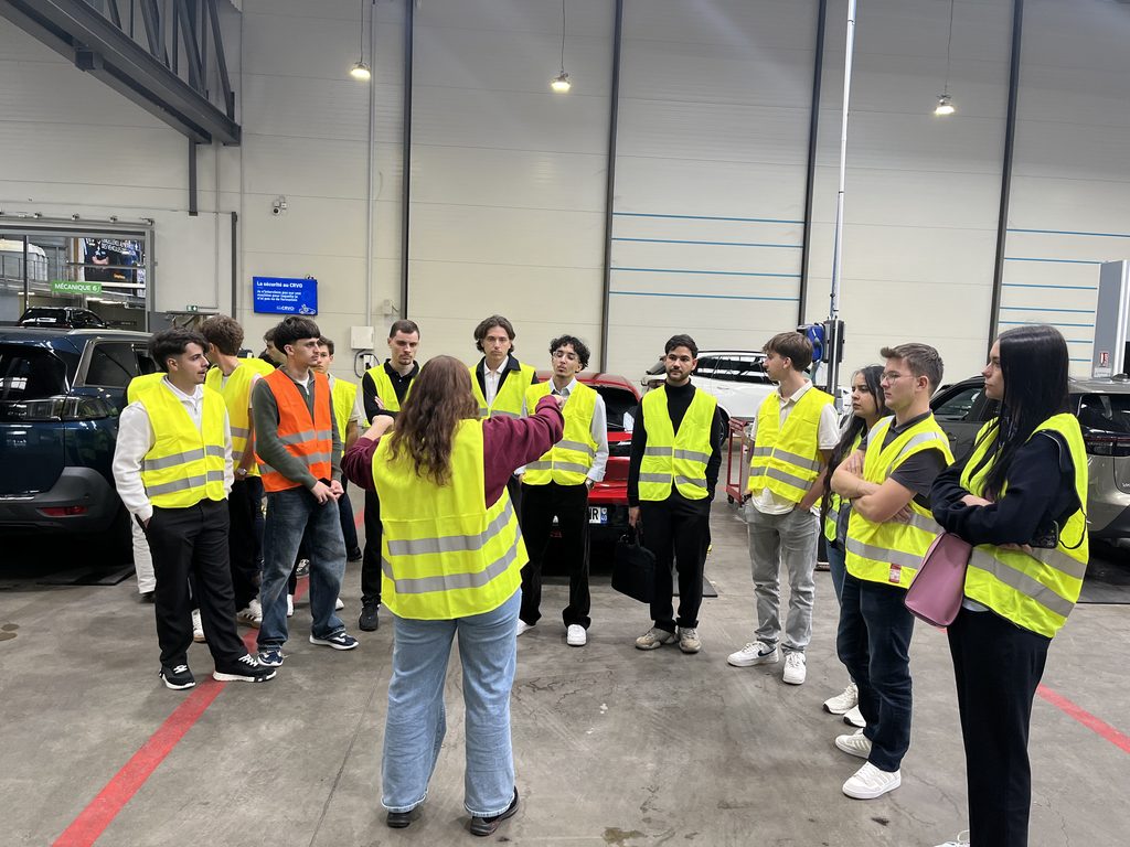 Les étudiants EFFy Pro School, alignés côte-à-côte, écoutent l'animatrice de la visite.